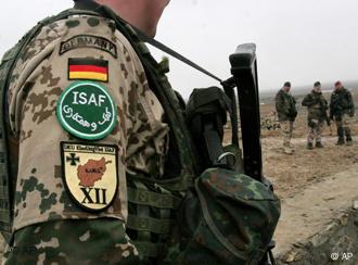 Patches of the German flag and ISAF emblem are visible on a German soldier's upper arm